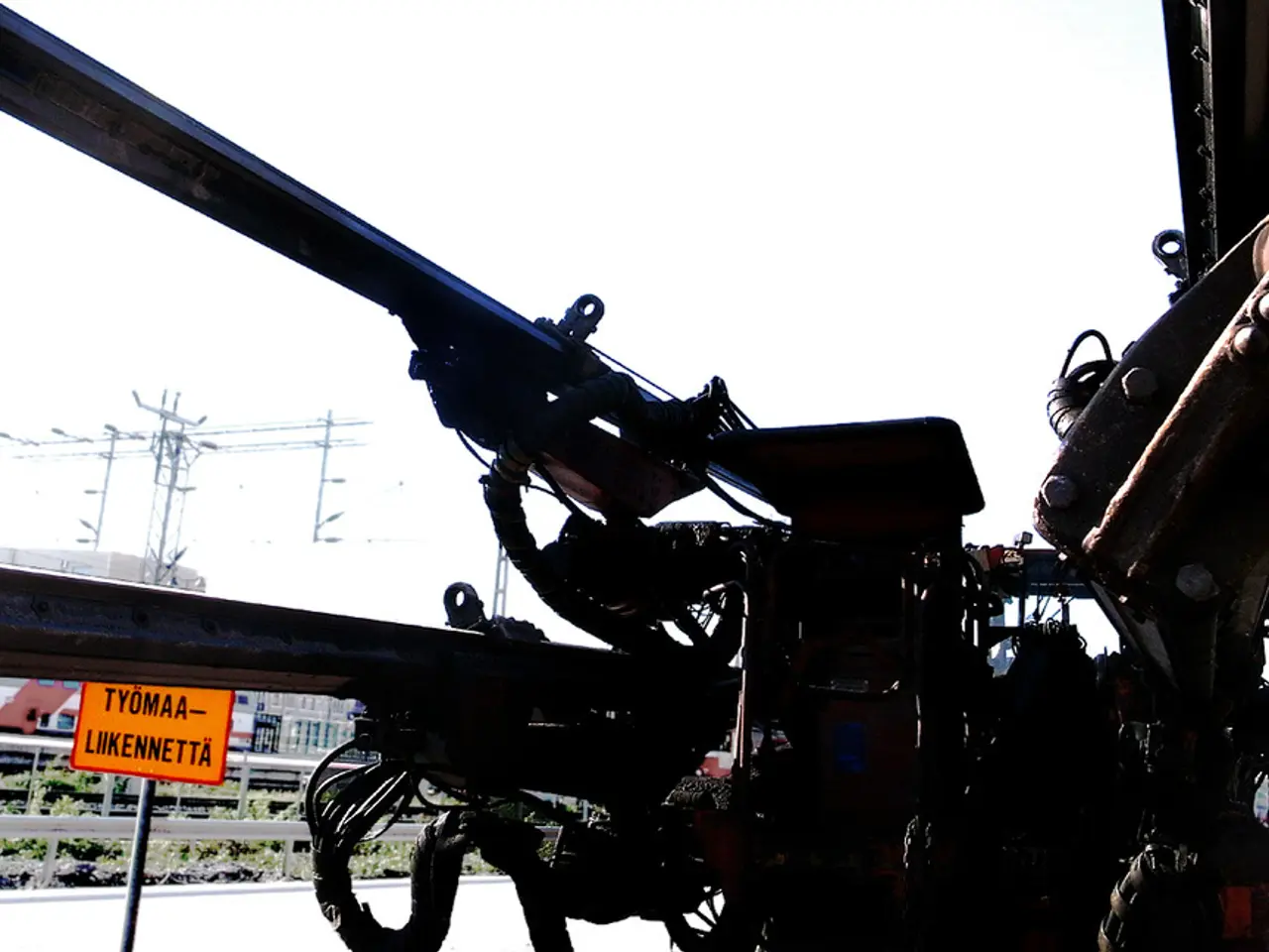 In this image we can see a machine. In the background there are electric poles, electric cables,...