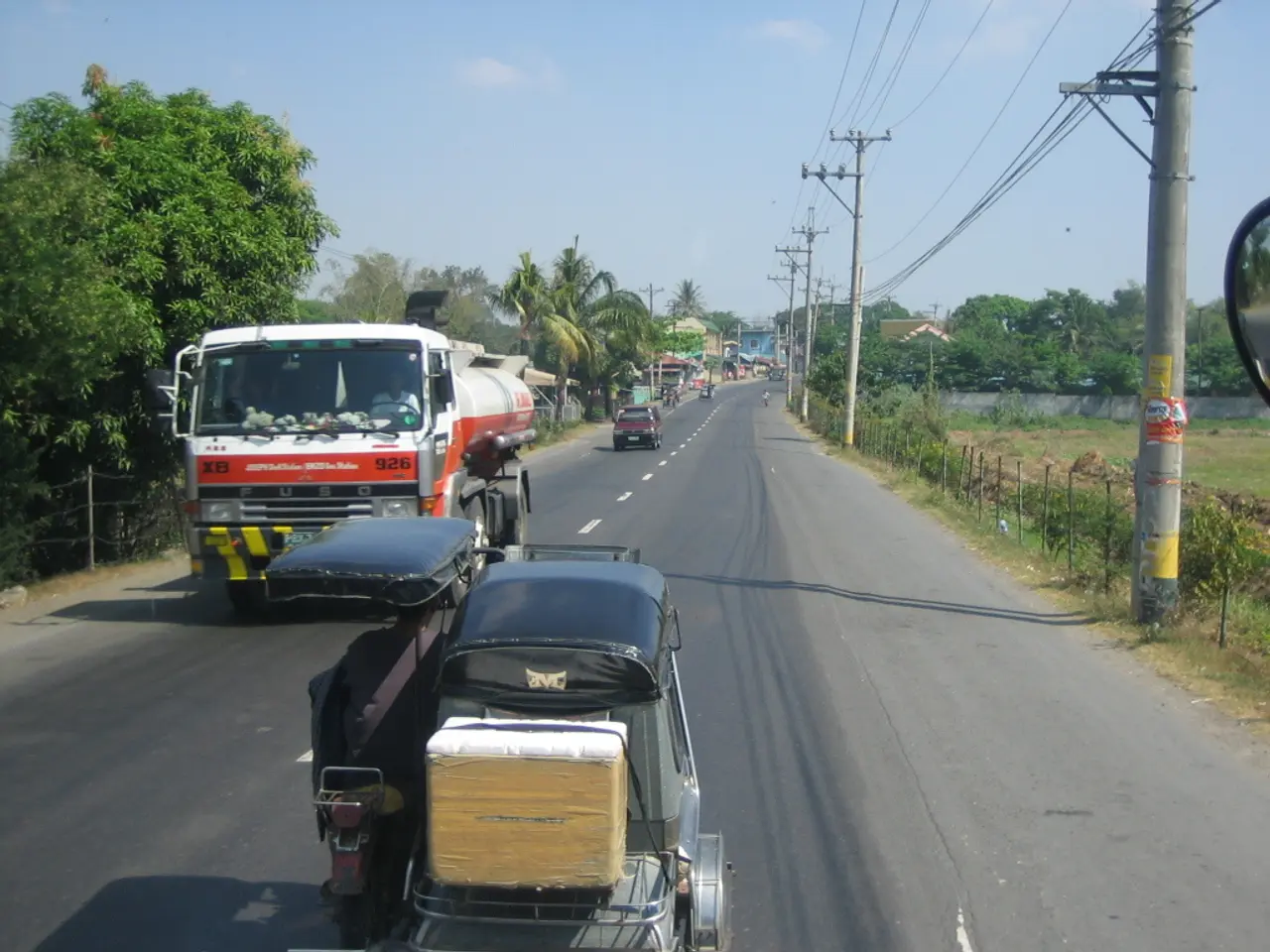 In this picture we can see the truck driver who is riding a track on the road. At the bottom we can...