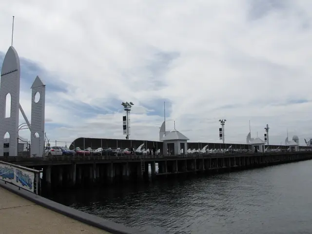 In this picture there are cars on the bridge in the center of the image and there is water at the...