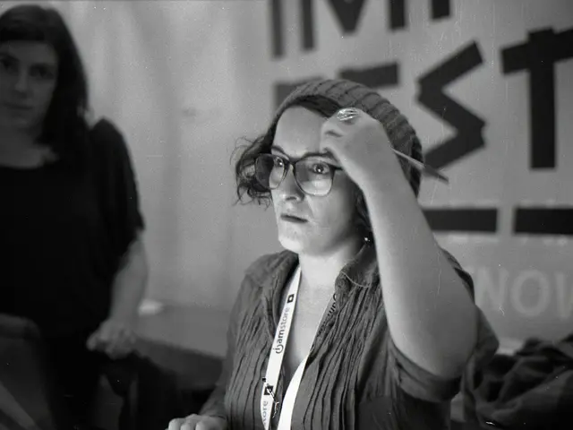 It is a black and white picture of two women and one woman is wearing an identity card. In the...