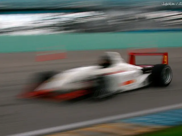 In this image we can see a car, road and a blurry background.