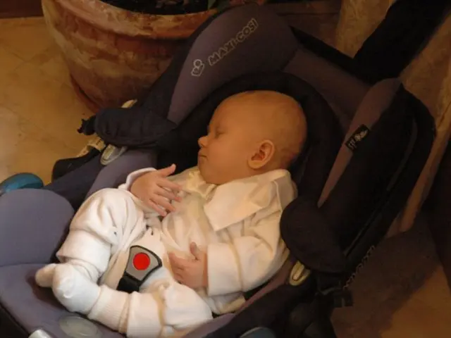 This image consists of a baby sleeping in a trolley. At the bottom, there is a floor. On the left...