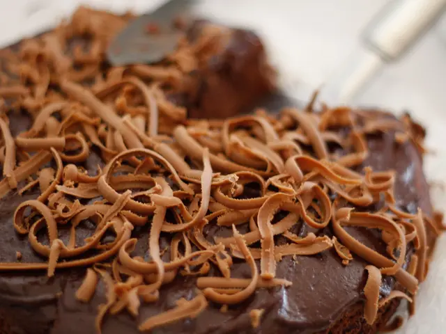 In this image we can see some food items on the chocolate, and the background is blurred.