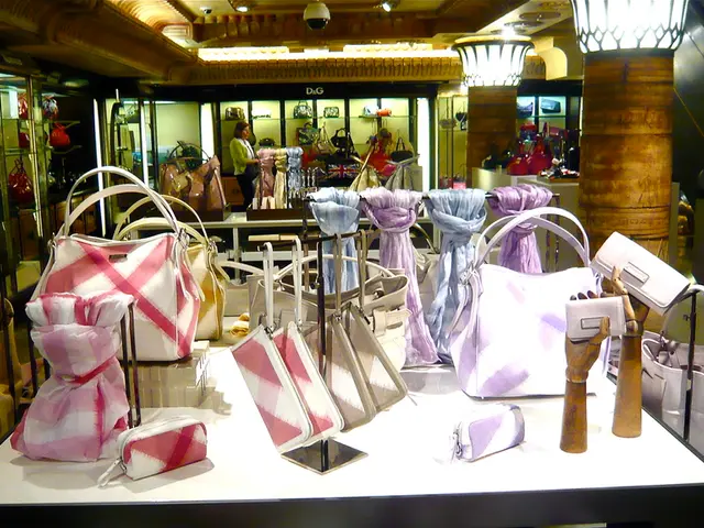 It is a bag store. There are some bags,valets and scarves placed. In the mirror reflection, we can...