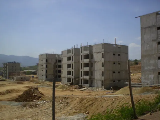 In this image there is a land in that land there are buildings, in the background there is the...