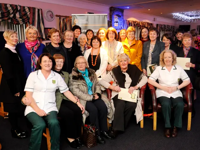 In this image, in the foreground there are five women, they are sitting. In the middle there are...