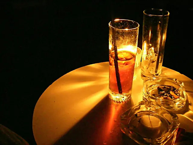 In the picture we can see a round table on it we can see two glasses of drink with some ice cubes...